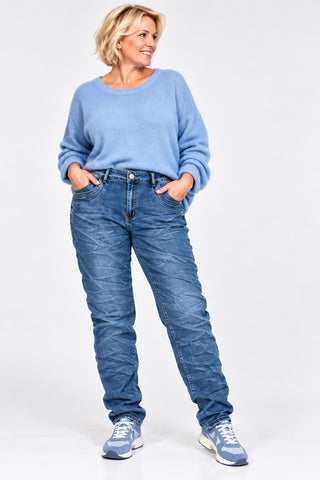 KAROSTAR Stretch-Jeans mit hohem Bund, leichter Crash-Optik und dekorativem Schmuck-Knopf am Curvy-Model.