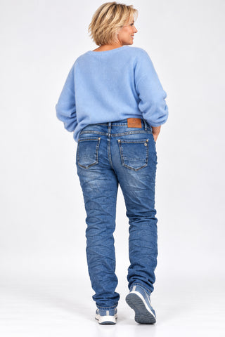 KAROSTAR Stretch-Jeans mit hohem Bund, leichter Crash-Optik und dekorativem Schmuck-Knopf am Curvy-Model.