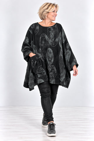 Oversize-Shirt in schwarz aus Feincord mit großem Kreismuster, geraffter Tasche und asymmetrischem Saum